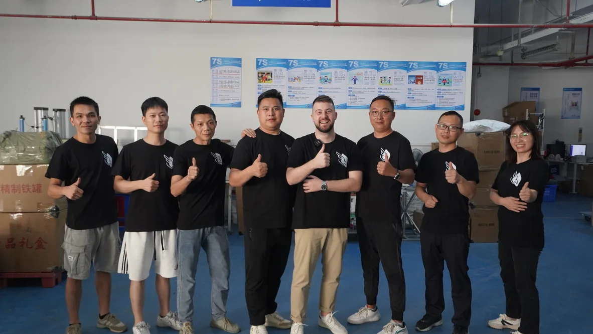 Peregrine Ship Shenzhen team — nine operators in branded t-shirts lined up inside the Bao'an warehouse